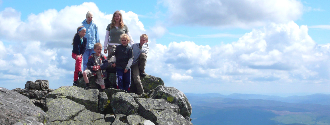 Family with young children on rocky hilltop in Scotland