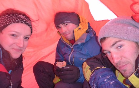 Climbers take shelter under a bothy bag